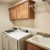 Laundry room with large capacity W/D, cabinets, clothes hanging shelf and wash sinkwash sink