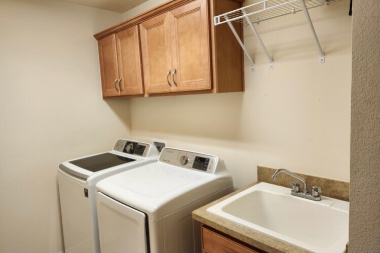 Laundry room with large capacity W/D, cabinets, clothes hanging shelf and wash sinkwash sink